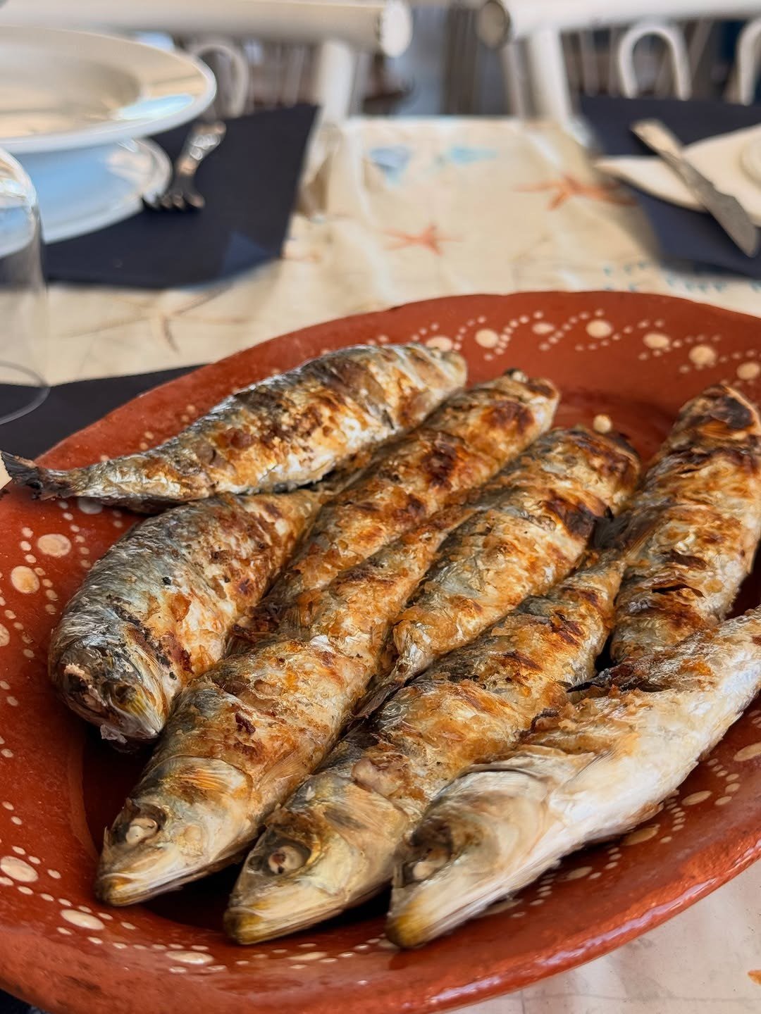 Sardinhas grelhadas num prato de barro