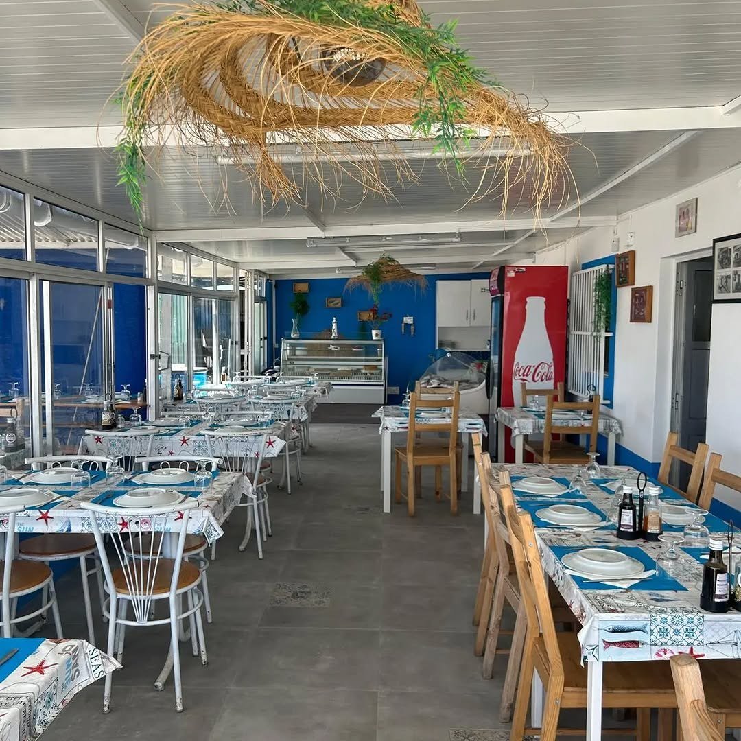 Sala com toalhas de padrão azul, cadeiras de madeira e parede azul ao fundo